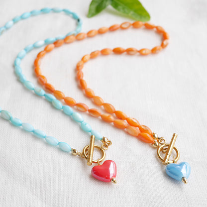 Orange beaded necklace - blue porcelain heart charm, toggle clasp